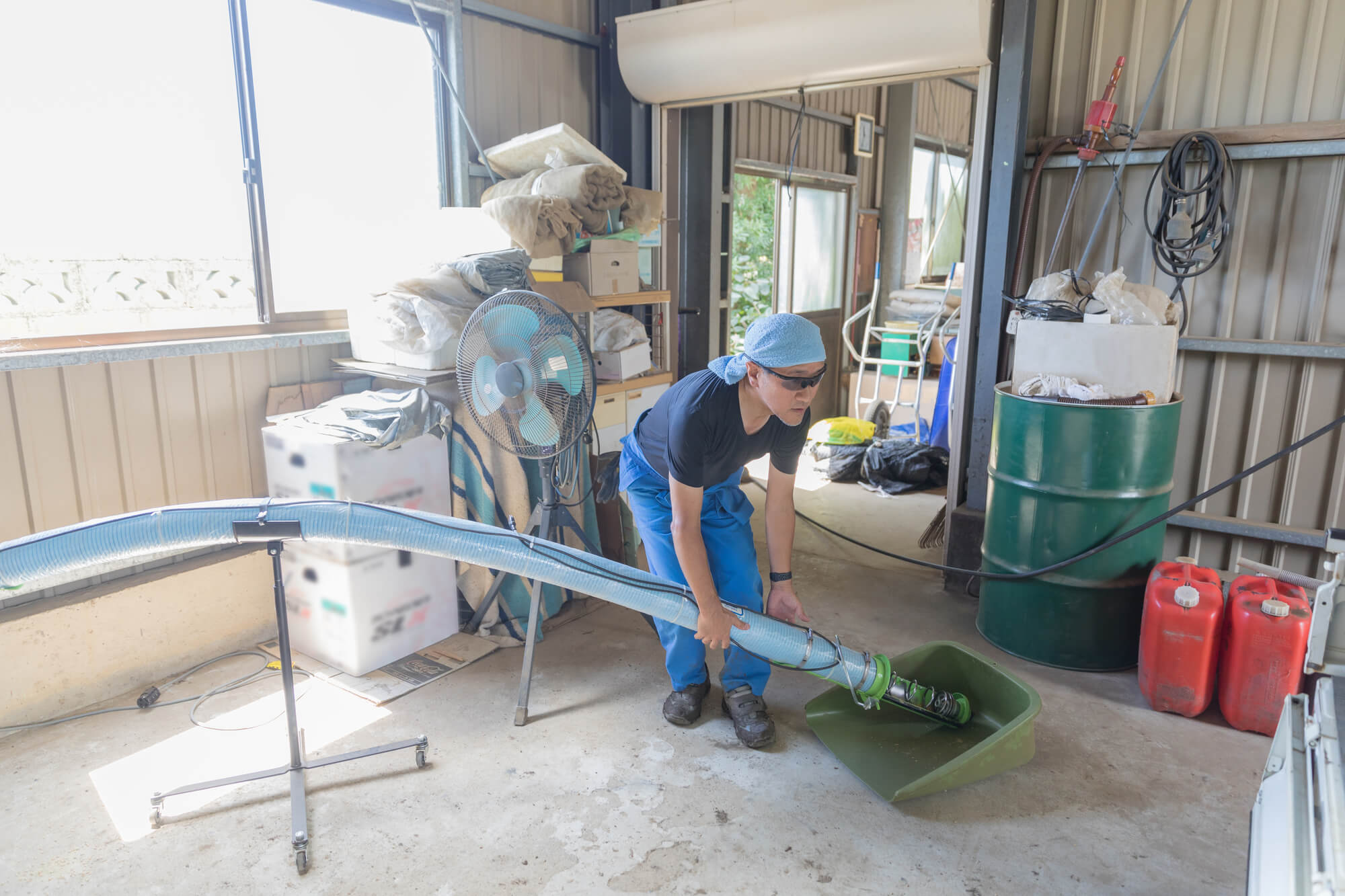 農業法人の乾燥施設で配管やダクトから籾殻や細かいゴミを取り除く作業の様子